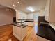 This kitchen boasts white cabinets, black countertops, and hardwood flooring for a clean and stylish look at 6715 St Johns Ct, Raleigh, NC 27616