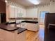 Well-lit kitchen featuring white cabinetry, black counters, stainless steel appliances, and hardwood floors at 6715 St Johns Ct, Raleigh, NC 27616