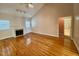 Open living room featuring vaulted ceilings, a fireplace, and gleaming hardwood floors at 6715 St Johns Ct, Raleigh, NC 27616