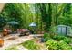 Spacious backyard featuring lush greenery, patio furniture, string lights, and storage shed at 7313 Longstreet Dr, Raleigh, NC 27615