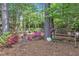 Tranquil backyard garden with iron bench, mature trees, and blooming azaleas at 733 Hadrian Dr, Garner, NC 27529