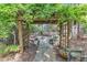 Charming backyard with a pergola-covered entrance, a stone patio, and lush landscaping at 733 Hadrian Dr, Garner, NC 27529