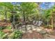 Spacious backyard area showing a stone patio with seating, lush landscaping and a tall heater at 733 Hadrian Dr, Garner, NC 27529