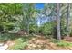 Large backyard featuring shade trees, lawn and landscaping with patio visible in the distance at 733 Hadrian Dr, Garner, NC 27529