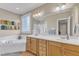 A bathroom featuring double sinks, wood cabinetry, a soaking tub and a separate shower at 733 Hadrian Dr, Garner, NC 27529