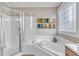 Bathroom featuring soaking tub, stand up shower with glass door and stained glass window at 733 Hadrian Dr, Garner, NC 27529