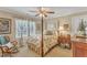 Cozy bedroom featuring a four-poster bed, window with decorative curtains, and a ceiling fan at 733 Hadrian Dr, Garner, NC 27529
