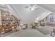 Bright bonus room featuring built-in bookshelves, neutral carpet, and comfortable wicker seating at 733 Hadrian Dr, Garner, NC 27529