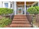 Inviting front door with brick steps, decorative wreath, and manicured shrubs enhances curb appeal at 733 Hadrian Dr, Garner, NC 27529