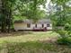 The backyard features a wooden deck, green grass, and mature trees, perfect for outdoor entertaining and relaxation at 81 Sallie Dr, Smithfield, NC 27577