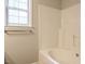 Bright bathroom featuring a tub and shower combination with a window for natural light at 81 Sallie Dr, Smithfield, NC 27577