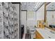 Bright bathroom featuring a patterned shower curtain, vanity with mirror, and window with blinds at 820 Nuttree Pl, Raleigh, NC 27606
