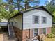 Two-story home with a brick foundation, light blue siding, and a wooden staircase to the deck at 820 Nuttree Pl, Raleigh, NC 27606