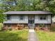 Inviting front exterior with light siding, brick foundation, and well-maintained walkway at 820 Nuttree Pl, Raleigh, NC 27606