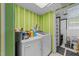 Laundry room with a washer, dryer, green striped wallpaper, and adjacent bathroom at 820 Nuttree Pl, Raleigh, NC 27606