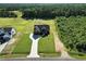 An aerial view of a dark, craftsman style home surrounded by lawns and forest at 8629 Dukes Lake Rd, Zebulon, NC 27597