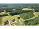 An aerial view displays homes in a forested area, demonstrating a peaceful and secluded setting at 8629 Dukes Lake Rd, Zebulon, NC 27597