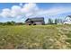 A dark-gray home stands on a broad lot with a screened-in porch and steps leading down to a spacious backyard at 8629 Dukes Lake Rd, Zebulon, NC 27597