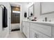 Modern bathroom featuring double vanity with white cabinets and a separate shower and tub at 8629 Dukes Lake Rd, Zebulon, NC 27597