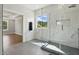 Modern bathroom featuring a glass-enclosed shower, marble walls, and a serene window view at 8629 Dukes Lake Rd, Zebulon, NC 27597