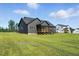 The back of a modern gray home with a screened-in porch and a spacious backyard at 8629 Dukes Lake Rd, Zebulon, NC 27597