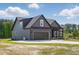 The exterior of this home showcases modern architecture and design, with a garage and well-maintained lawn at 8629 Dukes Lake Rd, Zebulon, NC 27597