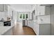 Bright kitchen features white cabinetry, stainless steel appliances, and views of backyard from large windows at 8629 Dukes Lake Rd, Zebulon, NC 27597