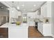 Open-concept kitchen featuring white cabinets, stainless steel appliances, and an island with a sink at 8629 Dukes Lake Rd, Zebulon, NC 27597