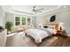 Sun-filled main bedroom boasts tray ceilings, neutral walls, and natural light from large windows at 8629 Dukes Lake Rd, Zebulon, NC 27597