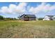 A dark-gray home stands on a broad lot with a screened-in porch and steps leading down to a spacious backyard at 8629 Dukes Lake Rd, Zebulon, NC 27597