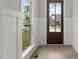Bright entryway featuring hardwood floors, paneled walls, and a solid wood front door with neighborhood views at 9305 Field Maple Ct, Raleigh, NC 27613