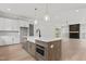 Open-concept kitchen featuring an island with a sink, stainless steel appliances, and a cozy fireplace in the living area at 9305 Field Maple Ct, Raleigh, NC 27613