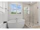 Bathroom features soaking tub, glass shower, and a window with a view at 9309 Field Maple Ct, Raleigh, NC 27613