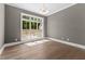 Sunlit bedroom features hardwood floors and a large window overlooking the front yard at 9309 Field Maple Ct, Raleigh, NC 27613