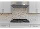 Close up of stainless steel cooktop with custom marble backsplash and ample counterspace at 9309 Field Maple Ct, Raleigh, NC 27613