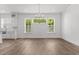 Dining room with hardwood floors, chandelier, and many windows with green outdoor views at 9309 Field Maple Ct, Raleigh, NC 27613