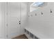 Mudroom features white shiplap walls, coat hooks, and a built-in bench with shoe storage at 9309 Field Maple Ct, Raleigh, NC 27613