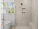 Bright bathroom shower features tile surround, glass door, and window at 9309 Field Maple Ct, Raleigh, NC 27613