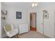 Cozy bedroom with white walls, a rocking chair, and an adjacent laundry area at 9404 Dawnshire Rd, Raleigh, NC 27615