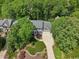 Aerial shot of a charming home nestled among mature trees, complemented by a curved driveway and manicured landscaping at 104 Montauk Point Pl, Cary, NC 27513