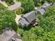 Aerial view of a home with a deck and gray roof surrounded by trees and manicured lawn at 104 Montauk Point Pl, Cary, NC 27513