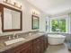 Bathroom with dual sink vanity, granite counters, and freestanding tub beneath a large window at 104 Montauk Point Pl, Cary, NC 27513