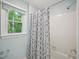Well-lit bathroom featuring a shower with a patterned shower curtain and window at 104 Montauk Point Pl, Cary, NC 27513