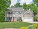 Beautiful two-story home with a landscaped front yard, gray siding, and a two-car garage at 104 Montauk Point Pl, Cary, NC 27513