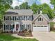 Traditional two-story home with gray siding, black shutters, and a well-manicured lawn at 104 Montauk Point Pl, Cary, NC 27513