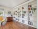 Bright living room featuring a wall of built-in bookshelves and hardwood floors at 104 Montauk Point Pl, Cary, NC 27513