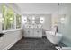 A pristine bathroom featuring double sinks, a modern tub, and a sleek glass-enclosed shower at 106 Circle Dr, Mebane, NC 27302