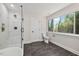 Well-lit bathroom featuring a glass shower and a toilet with a large window at 106 Circle Dr, Mebane, NC 27302