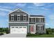 Charming two-story home featuring gray siding, black shutters, white trim, a red front door, and a two-car garage at 111 N Coral Bells Way Way, Four Oaks, NC 27524