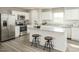 Modern kitchen featuring white cabinets, stainless steel appliances, granite countertops, and a center island with seating at 111 N Coral Bells Way Way, Four Oaks, NC 27524